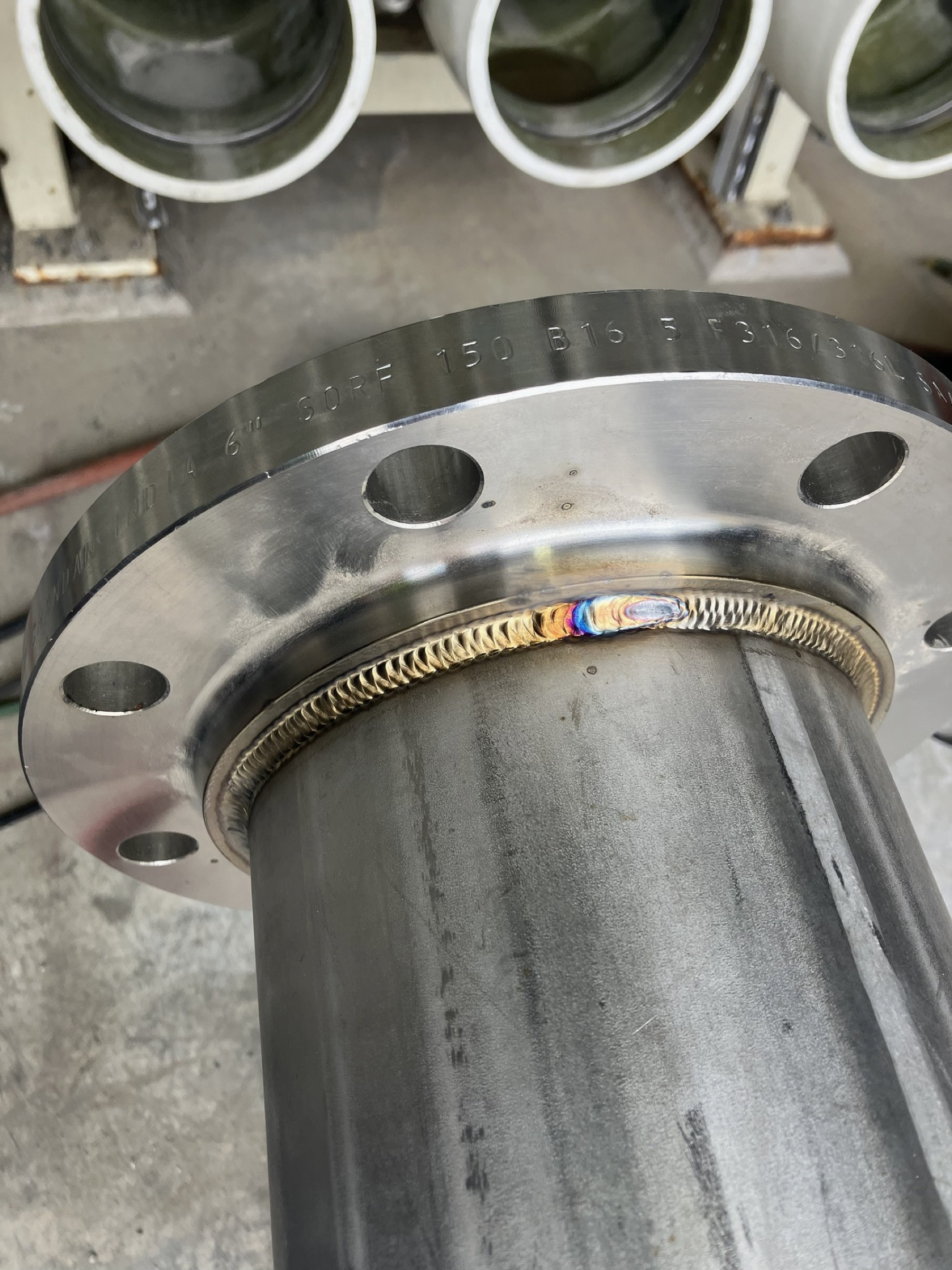 Close view of a stainless steel pipe-to-flange weld